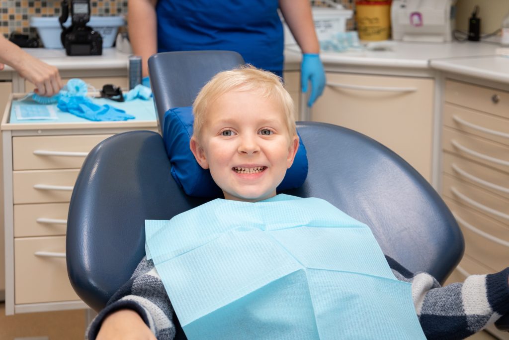 little boy at dentist s office child smiling whil 2022 11 10 09 30 29 utc