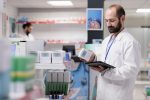 drugstore employee looking at drugs packages typin 2023 03 08 03 02 04 utc